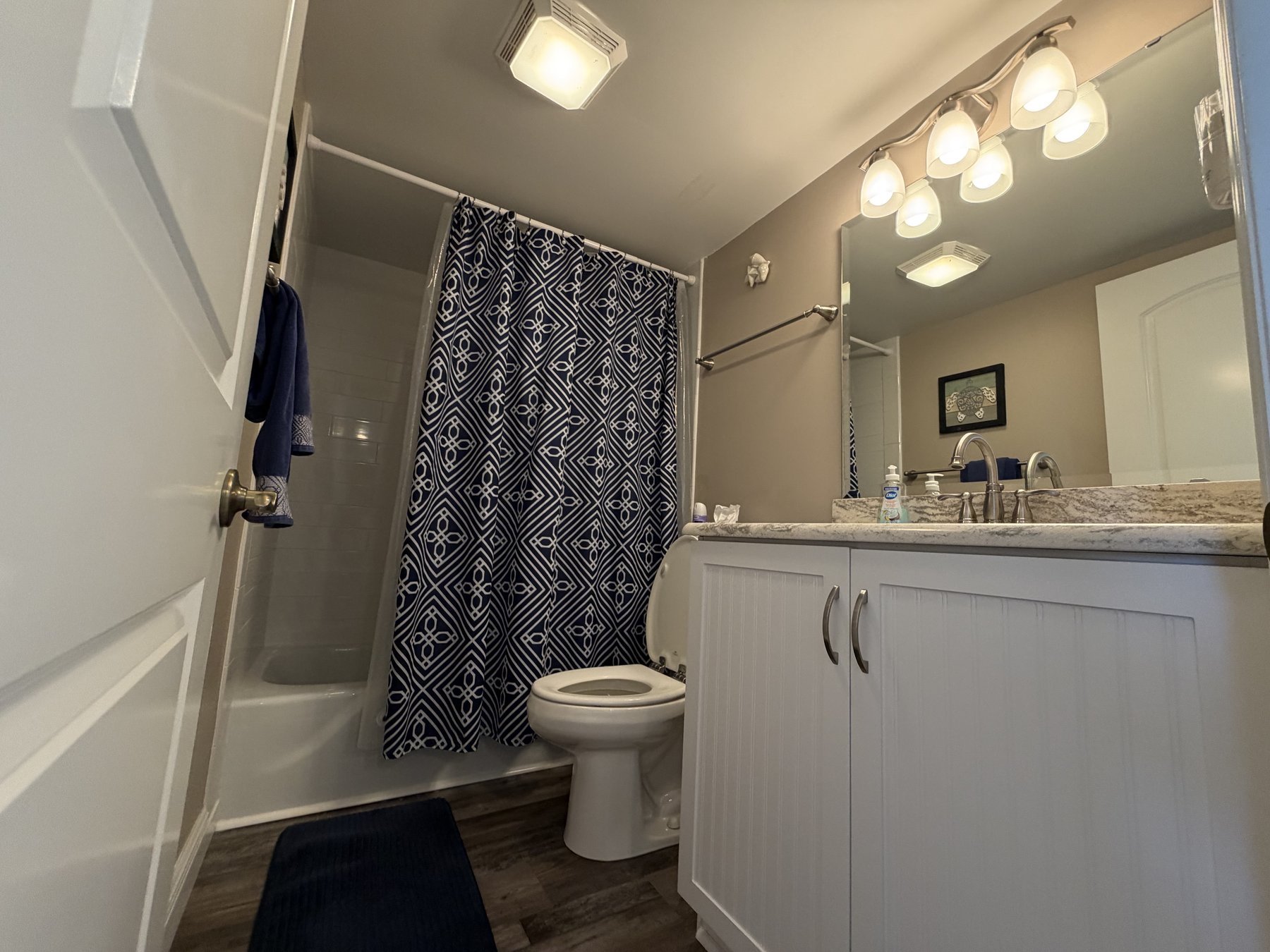 Primary bathroom tub and shower in rental unit 1005